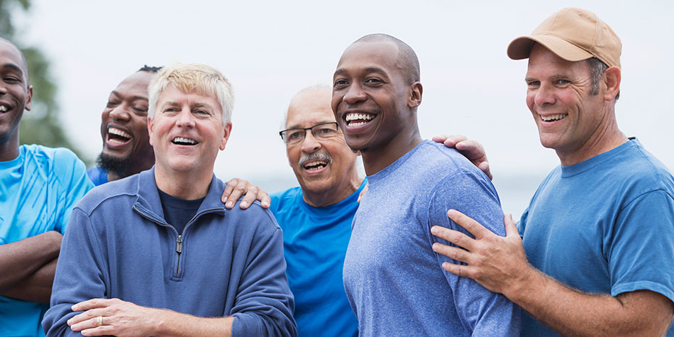 A group of men smiling and staring off into the distance.