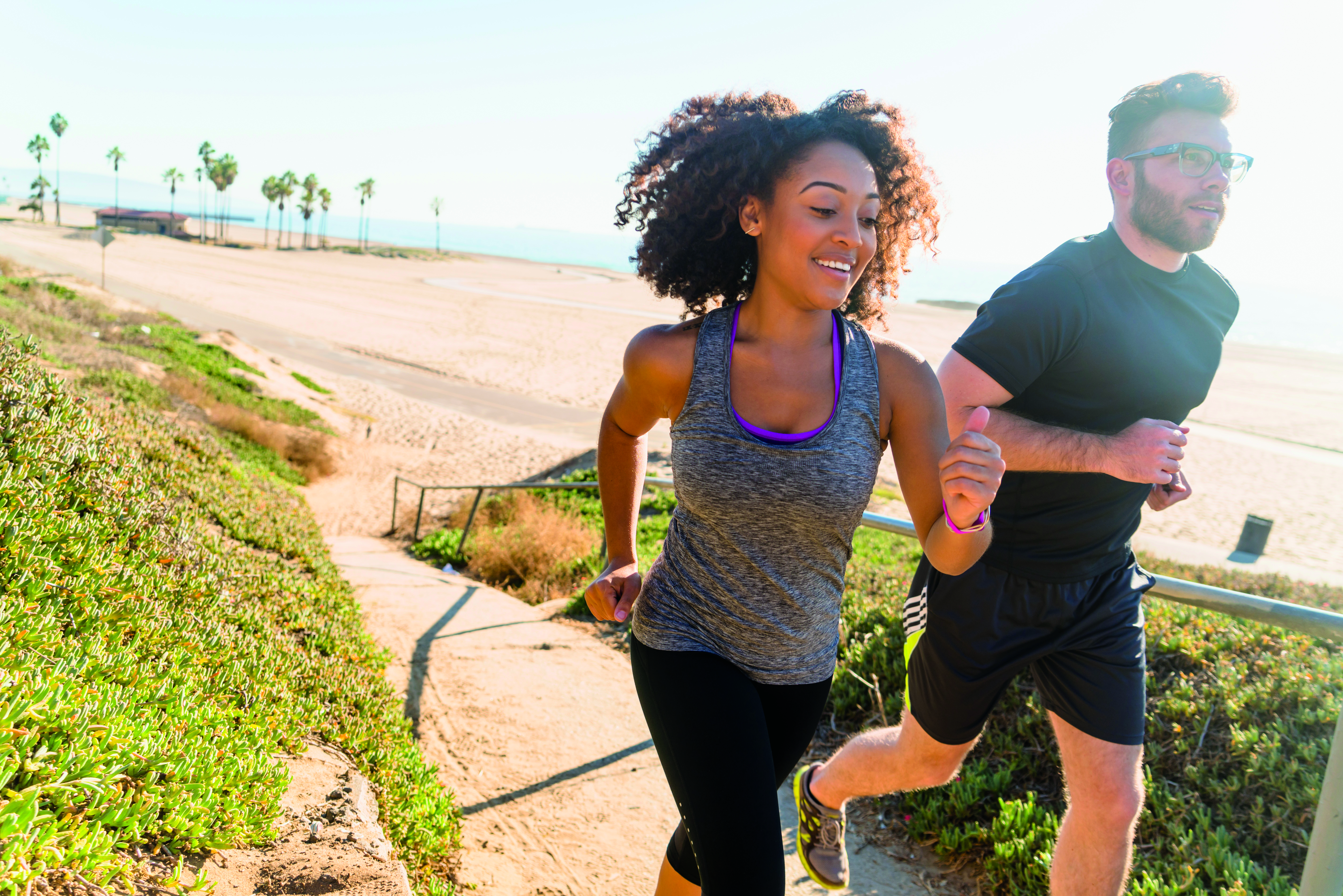 Young couple running along the beach.