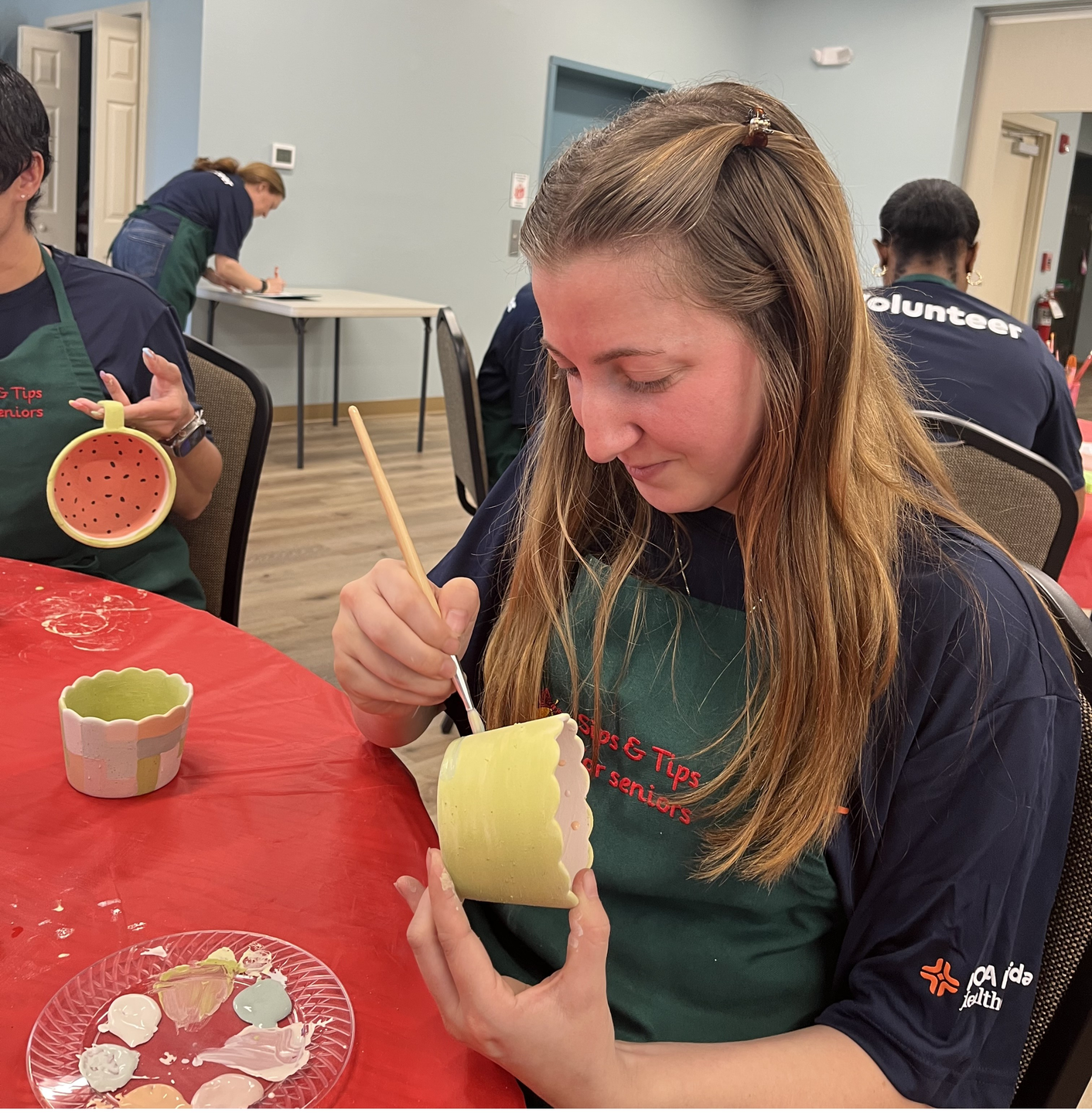 An HCA Florida Healthcare colleague paints ceramic bowls during a volunteer activity