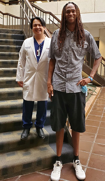 Aortic surgeon Dr. Kim de la Cruz standing next to former Harlem Globetrotter basketball player Jay 'Stretch' Middleton.