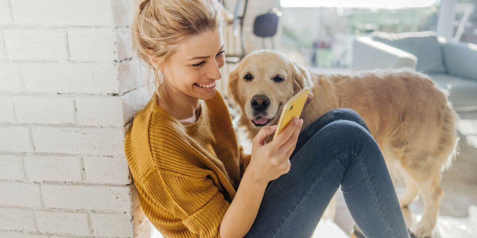 Smiling woman playing with dog