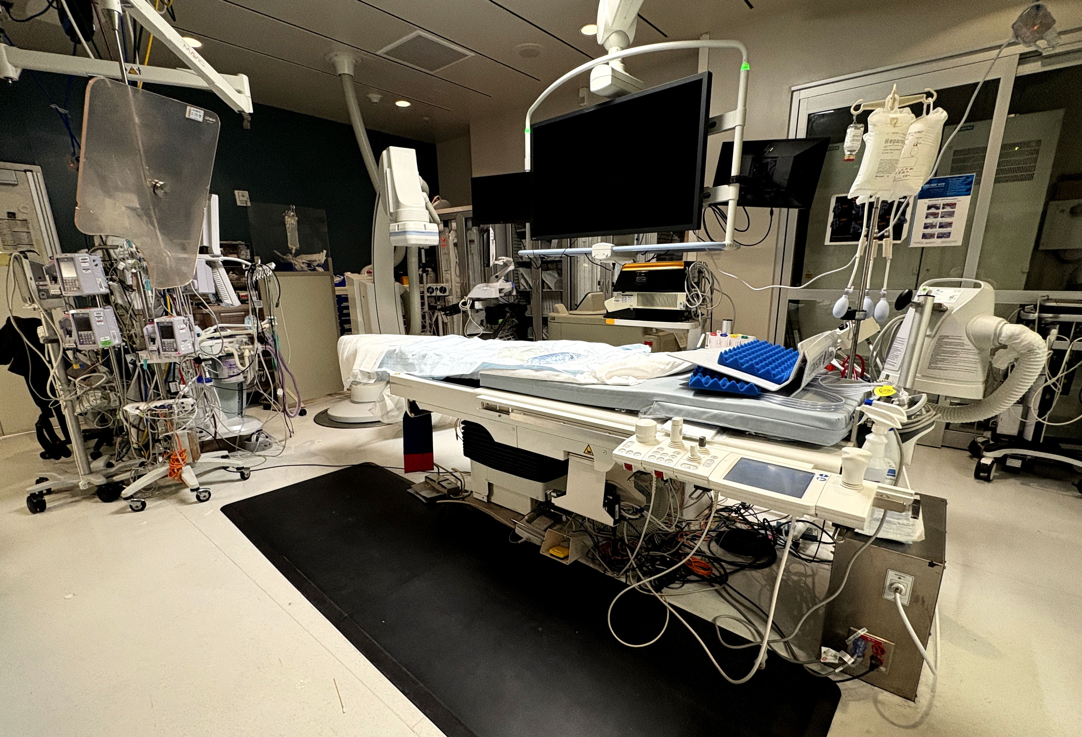 A hospital bed is prepped and ready in an empty room for an operation.