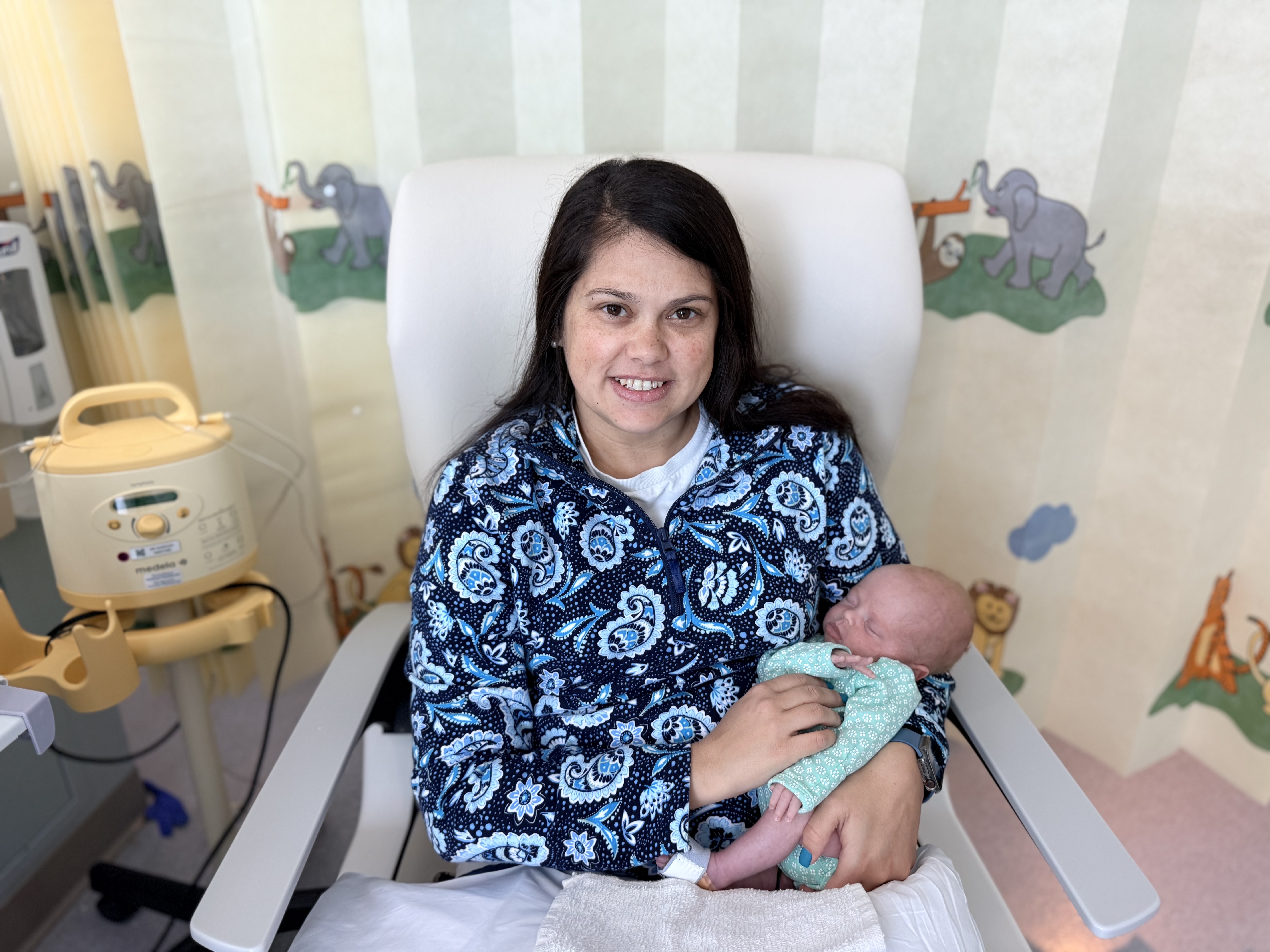 April holding her baby while in bed.