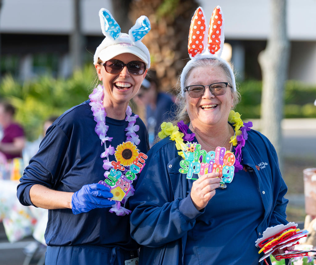 Nurses stand smiling.