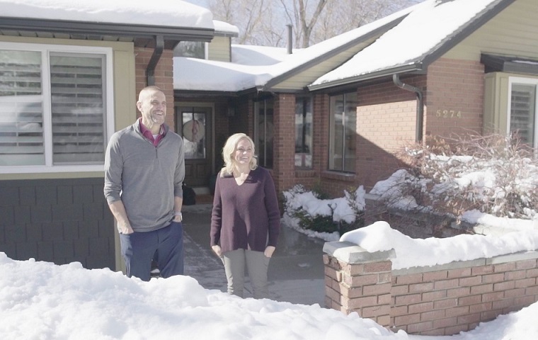 Nathan Barton and his wife standing outside their home in the wintertime.