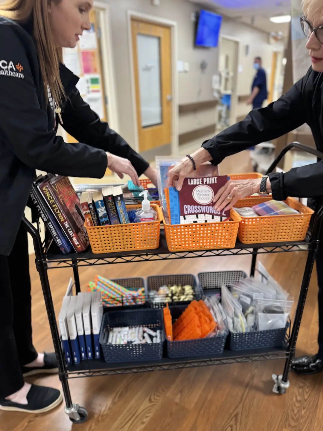 Irene Katrinecz works with Stephanie Rochelle to set up the book cart.