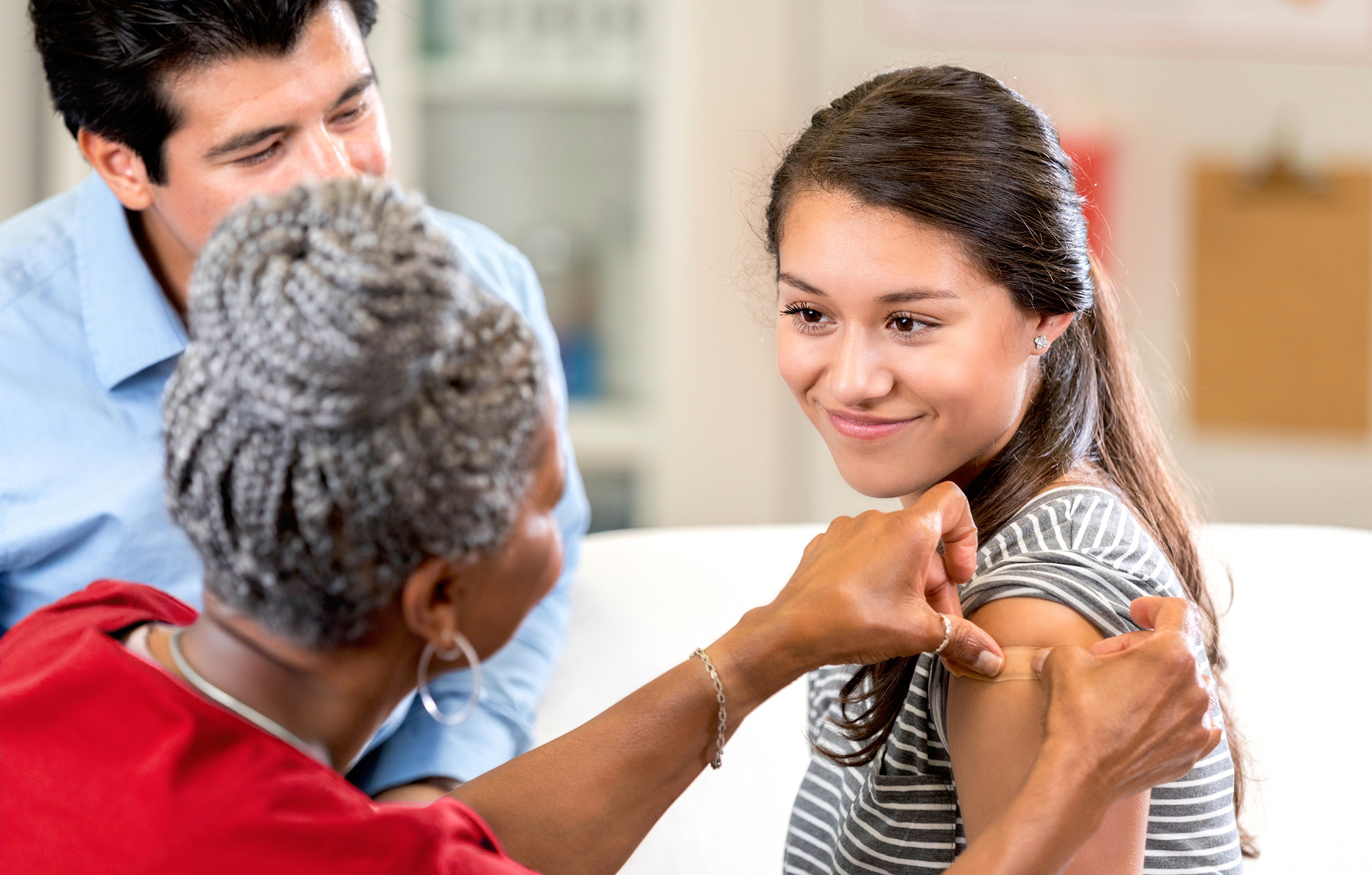 A nurse puts a bandage over the spot where a patient just received a flu shot