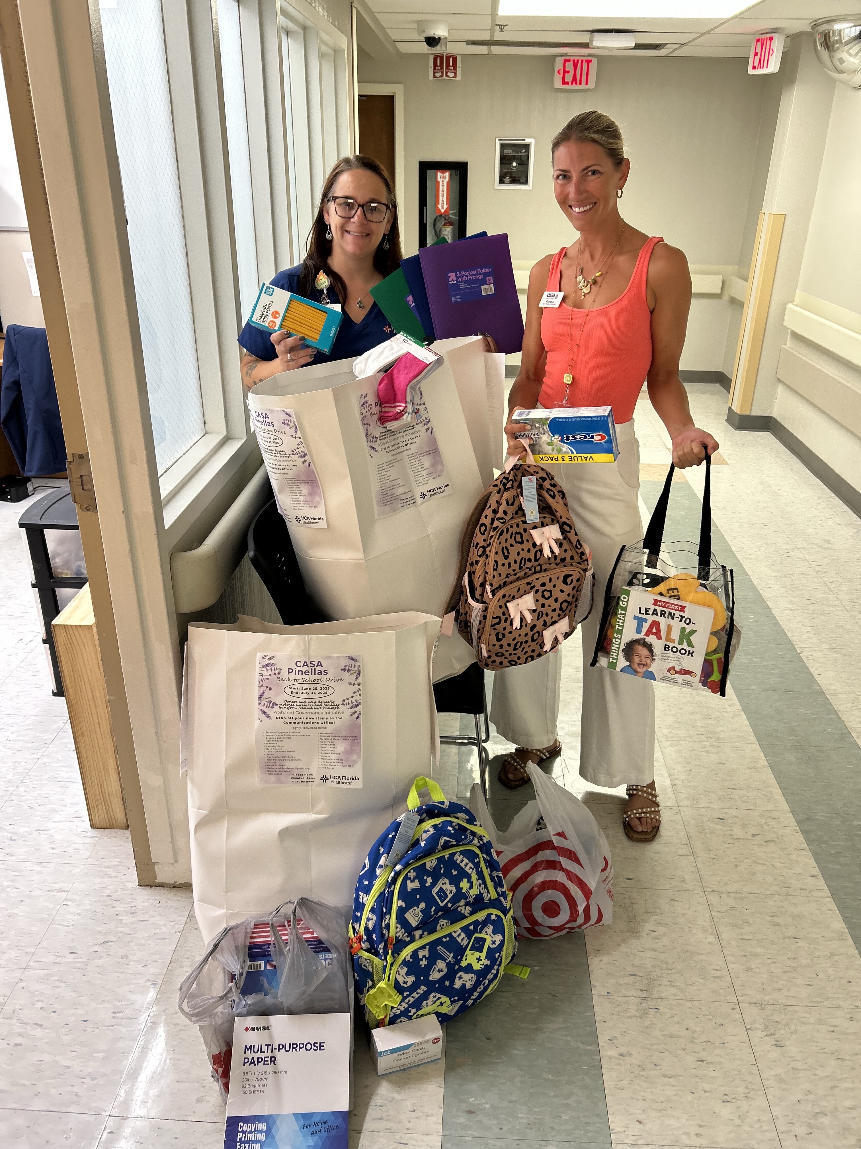 Photo of two females posing and smiling, showing essential donations for the mothers and children served by CASA (Community Action Stops Abuse).