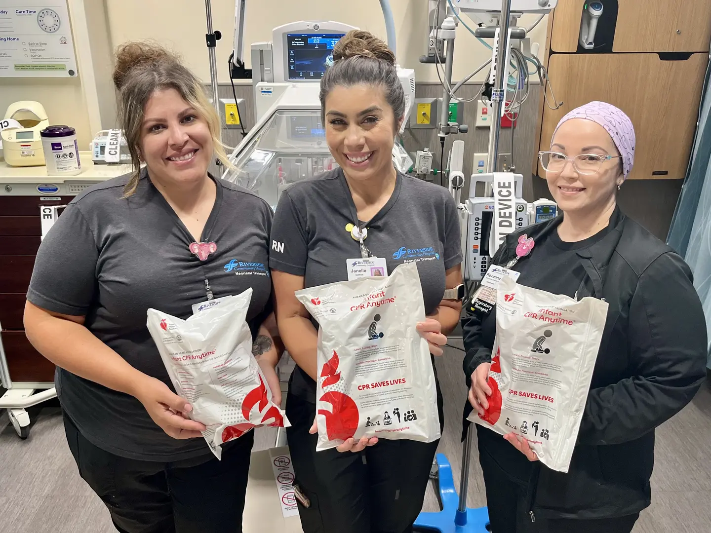 2 NICU nurses and a Respiratory Therapist hold some of the infant CPR kits