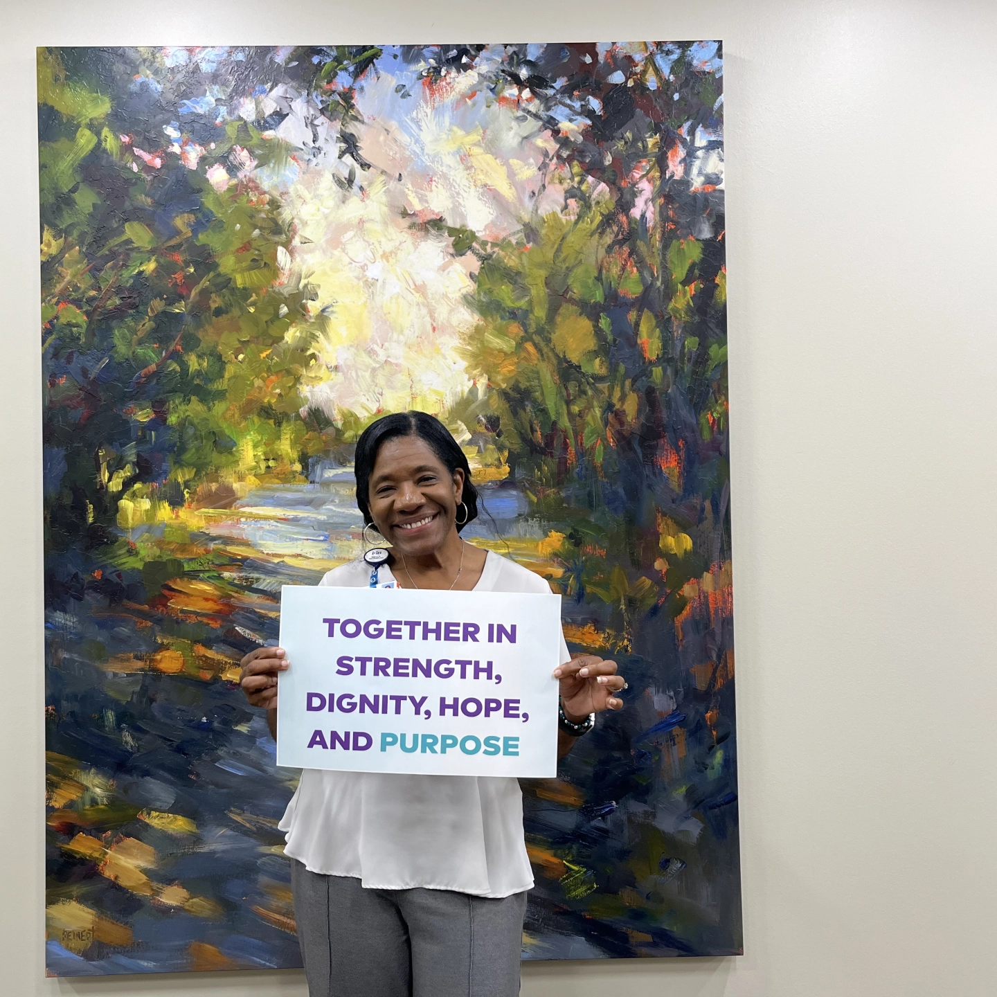 Methodist team member holds sign of encouragment on World Mental Health Day.