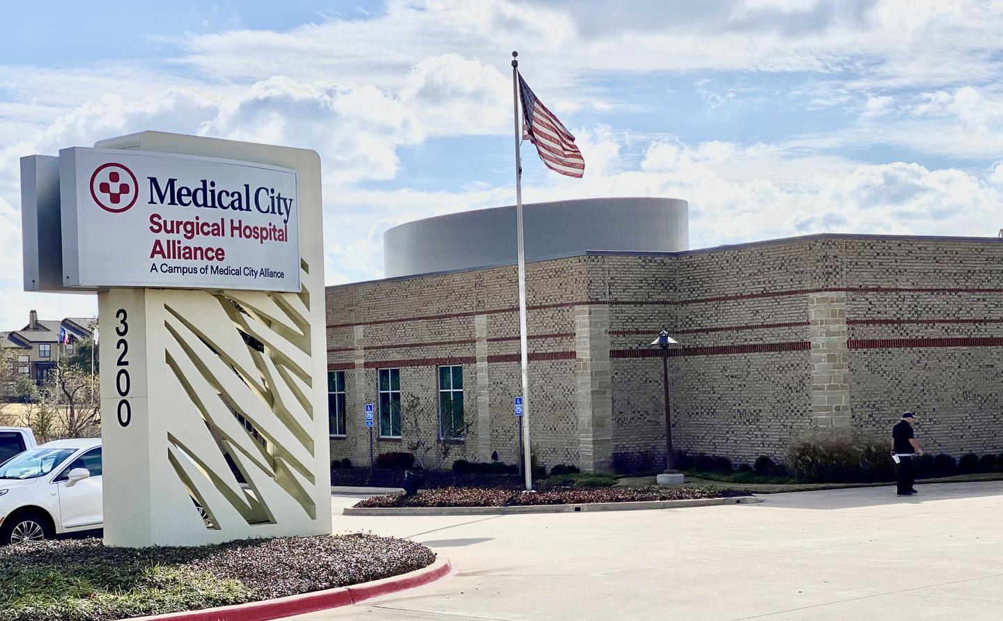 Exterior main entrance of the Medical City Surgical Hospital Alliance on a sunny day.