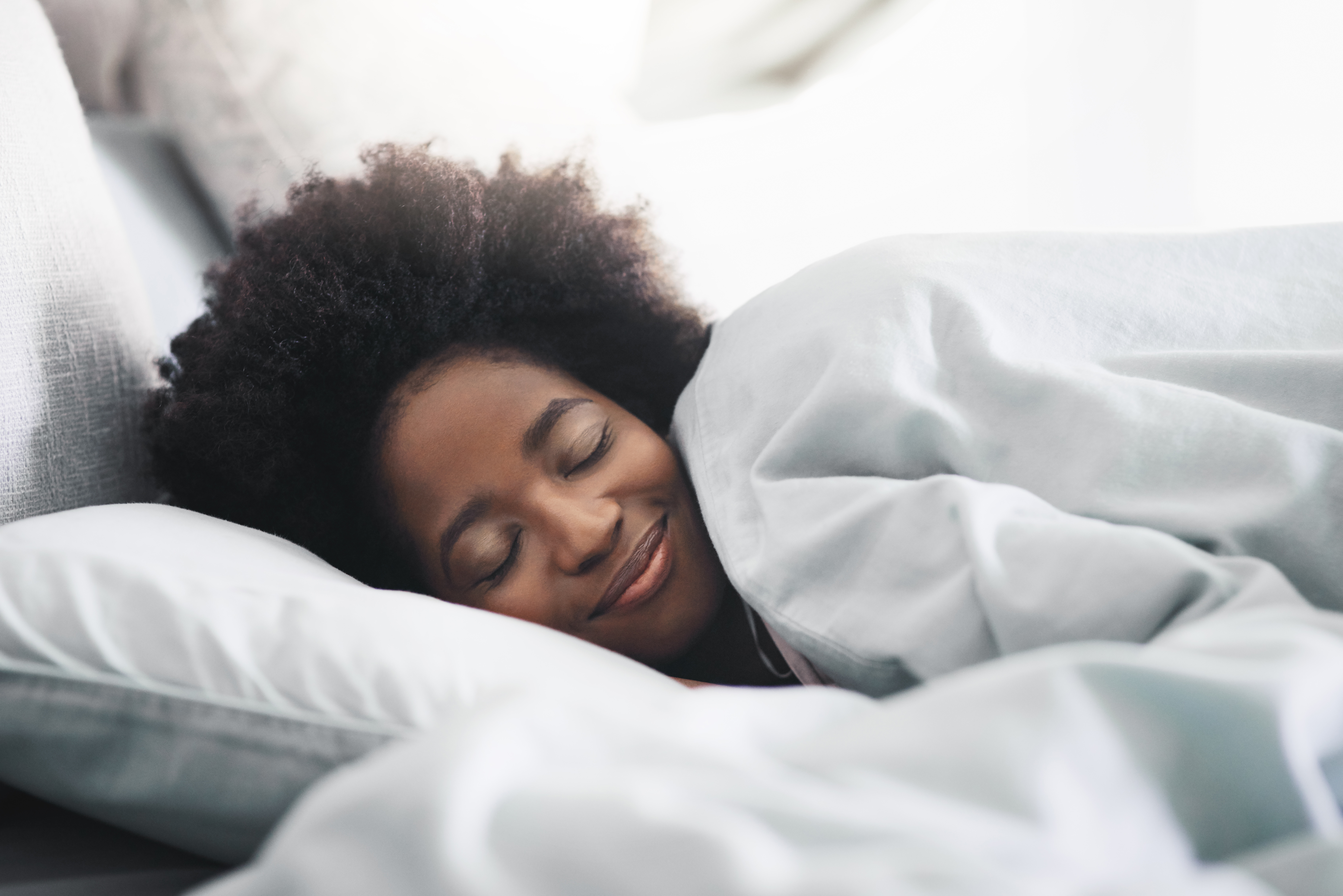 Photo of a young woman sleeping in her bed in the morning at home