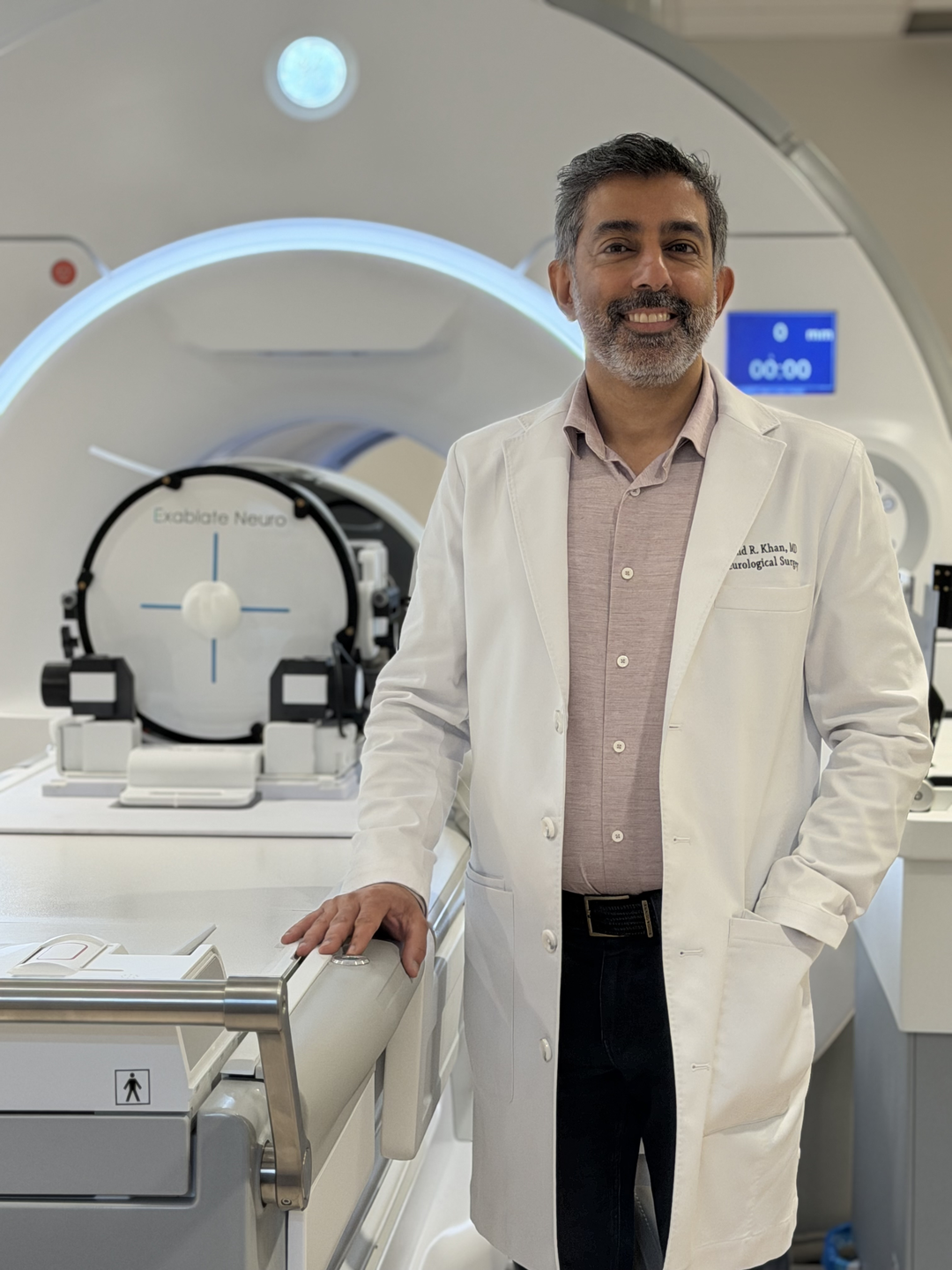 Dr. Khan stands next to the MRI Insightec equipment to be used during the procedure.