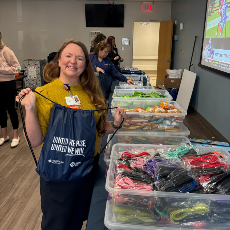 A Northside Hospital employee standing next to multiple bins full of items for donation.