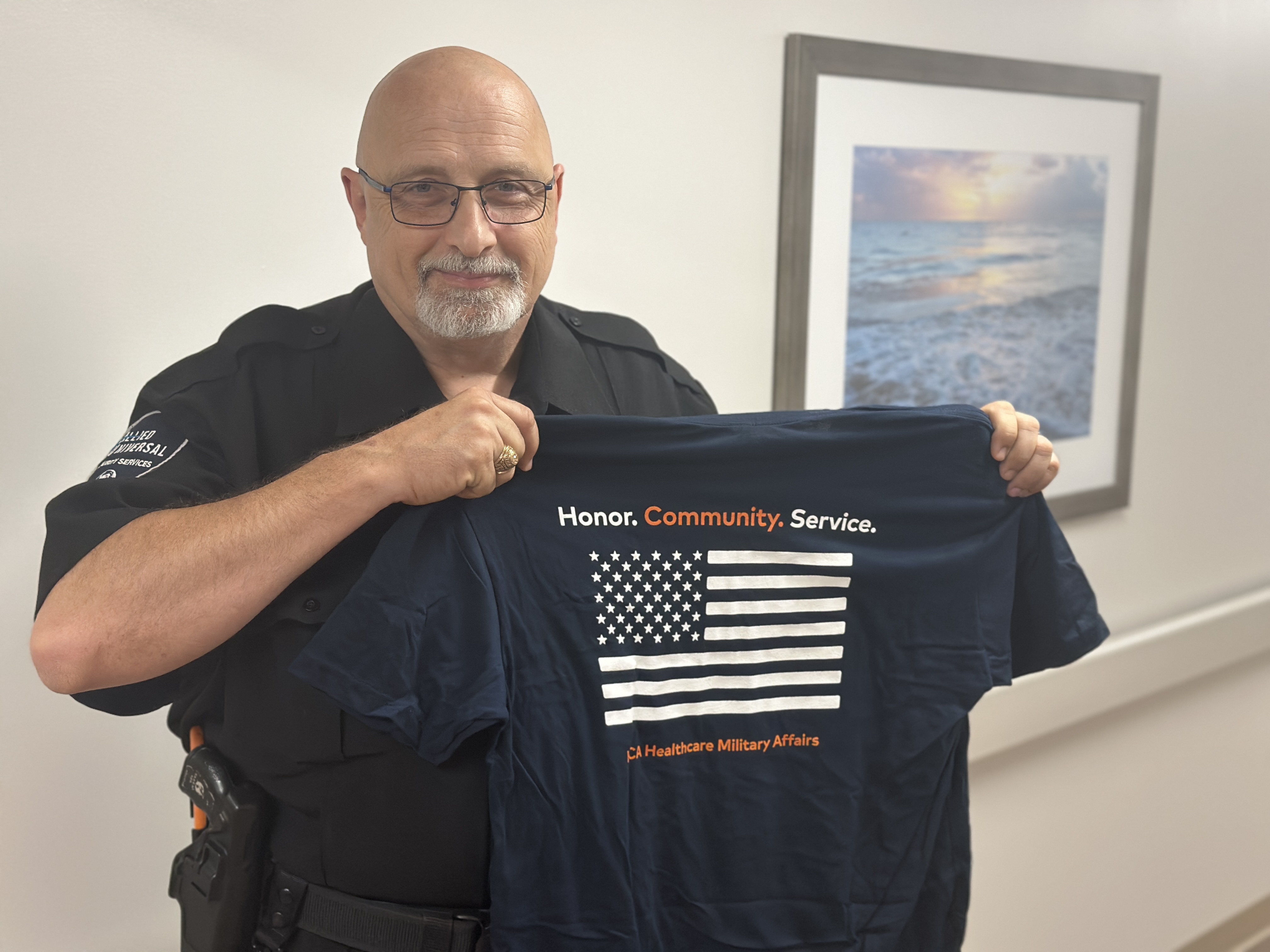 Captain Mark Benedict, security officer who served in the United States Marine Corps proudly shows off his HCA Healthcare veteran t-shirt.