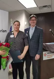 Woman stands holding flowers next to man