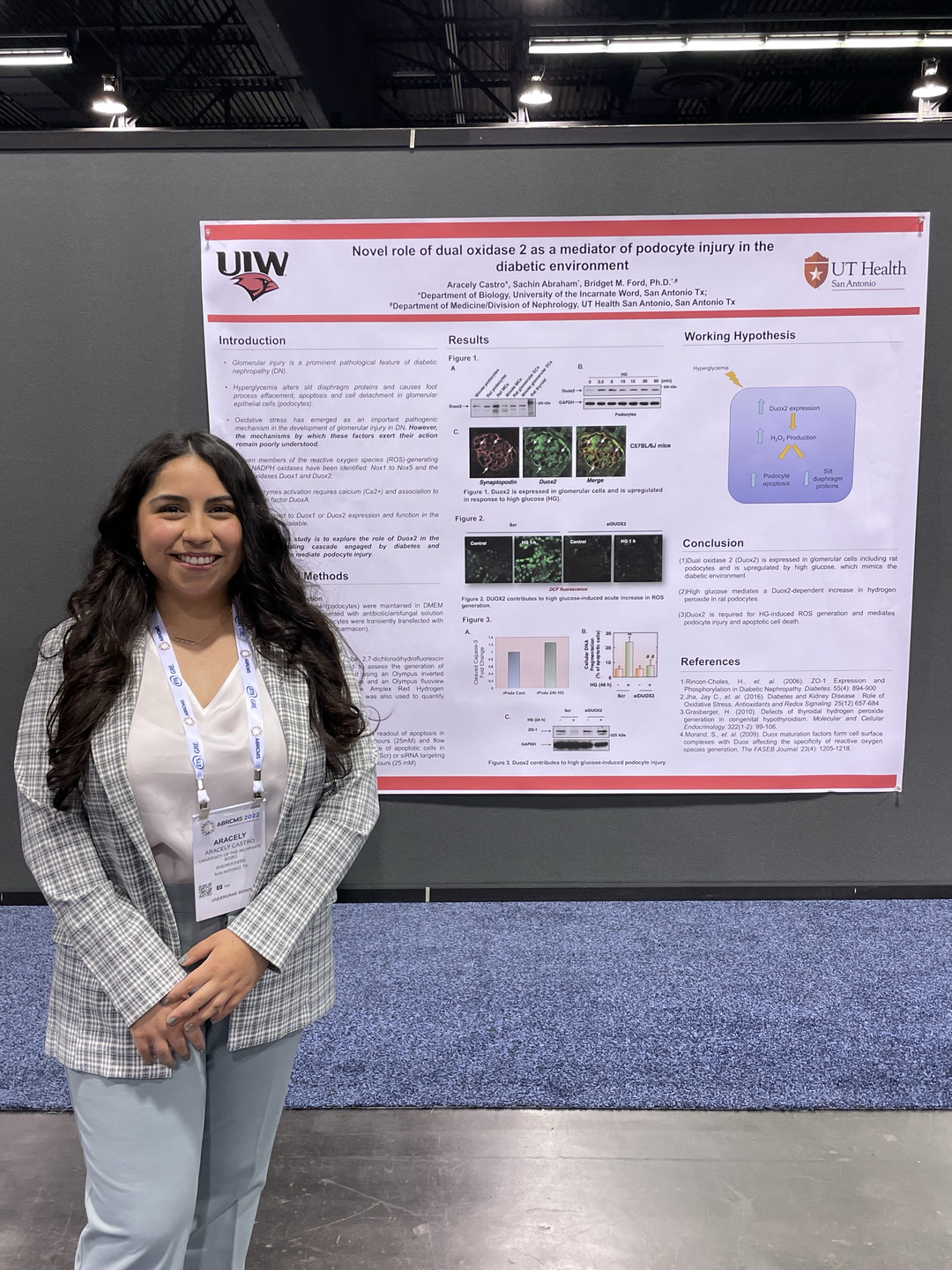 Aracely Castro standing next to a research presentation