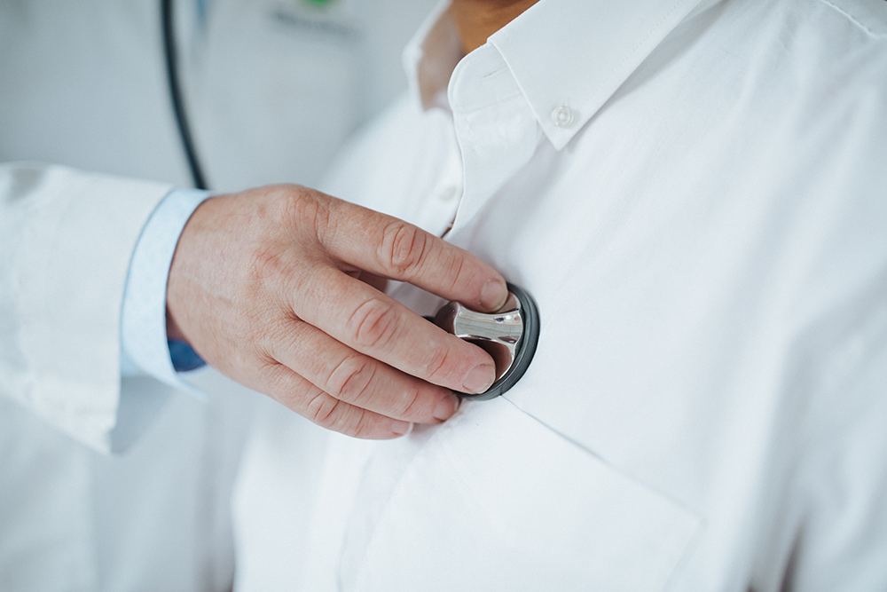 A doctor uses a stethoscope to listen to a patients heart.