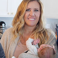 Tawnie smiles while holding one of her twins.