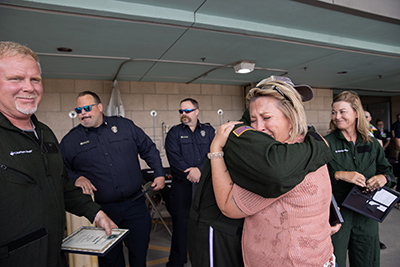 Shyann's mother cries while hugging one of the medical professionals who helped transport her daughter.