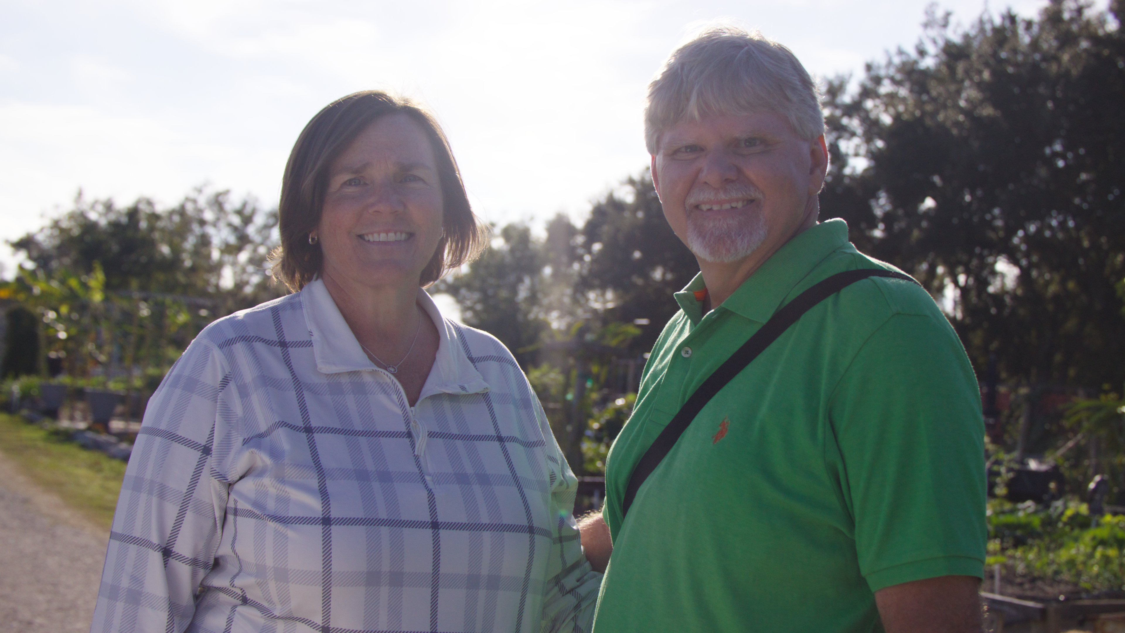 Jeff Pollier and wife standing outside while smiling.