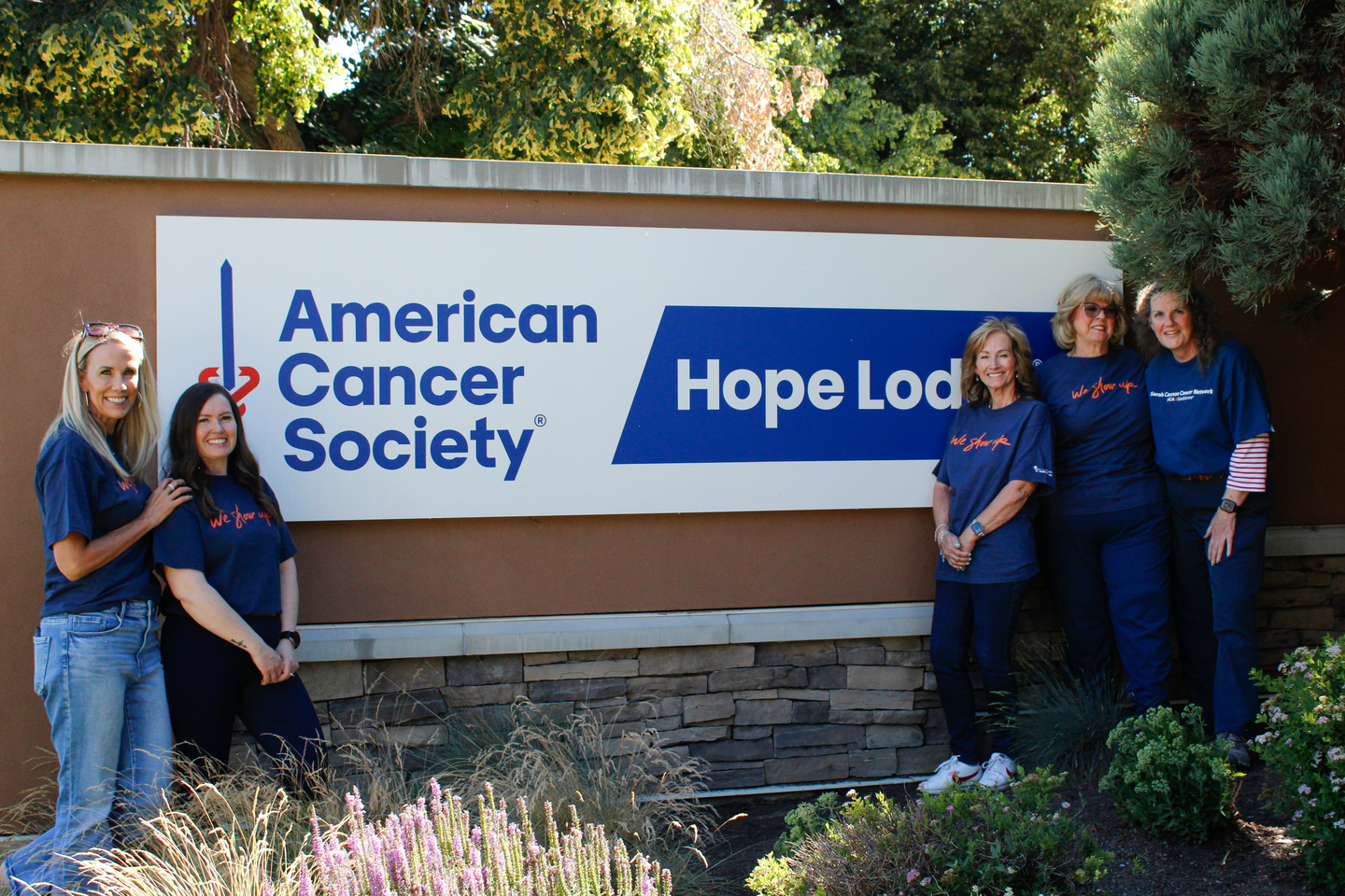 A group poses with the American Cancer Society billboard.