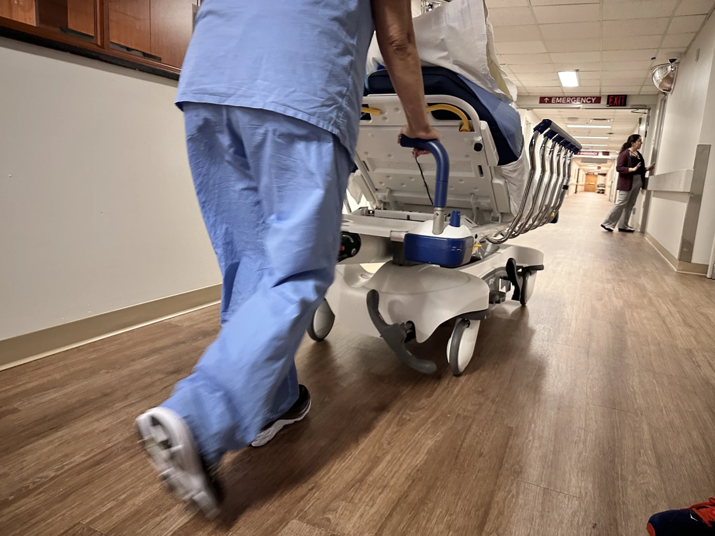 Englewood staff member pushing bed down a hallway.