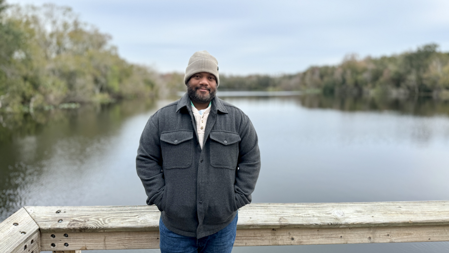 Photo of Victor Moreta standing in front of a lake.