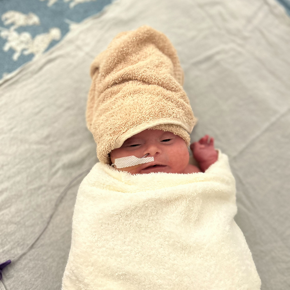 Newborn Bo, swaddled in crib.