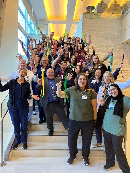 Group of people at Landmark Hospital celebrating on stairs