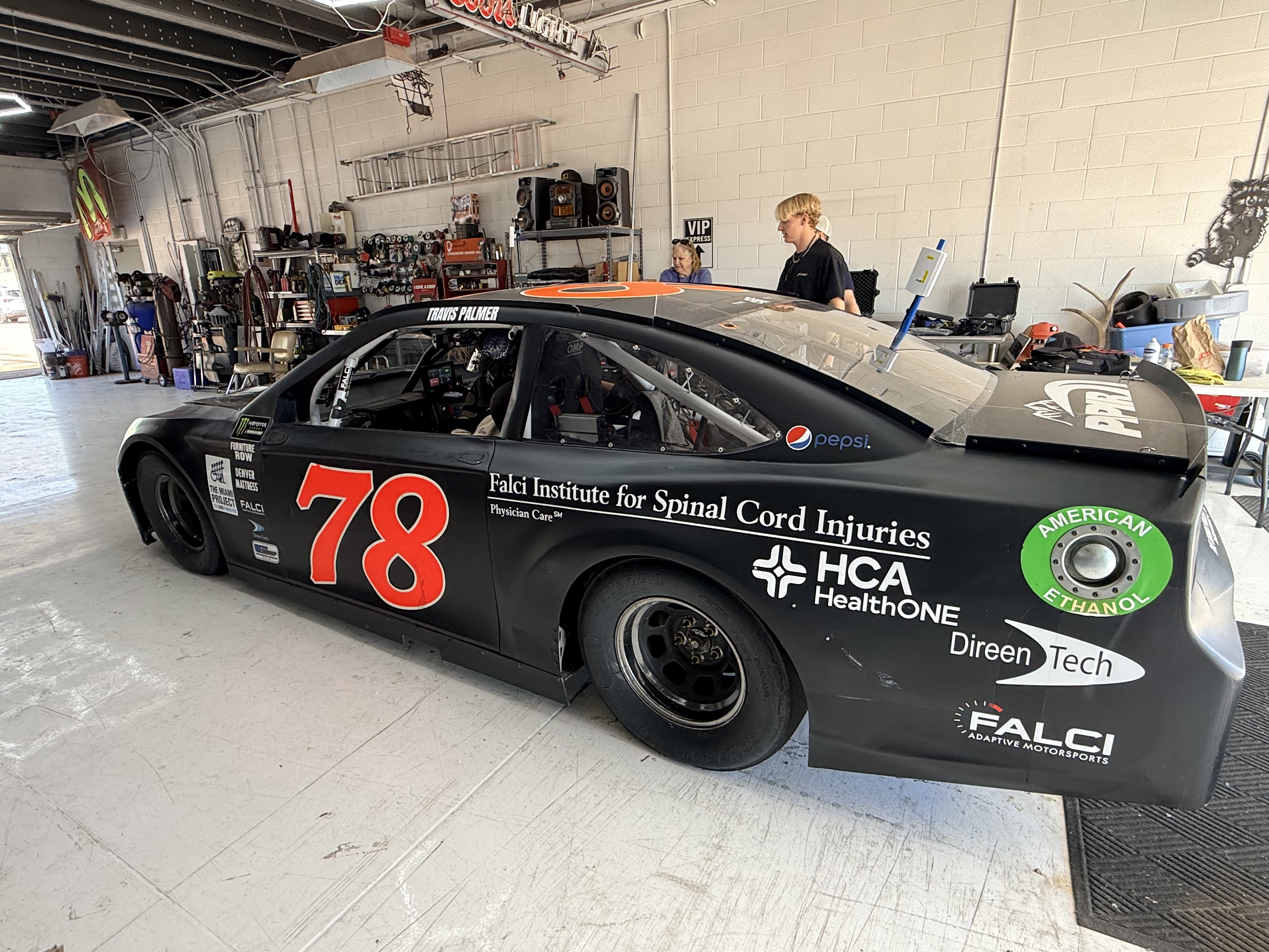 a #78 NASCAR vehicle with HCA HealthONE Falci Institute for Spinal Cord Injuries logo on it