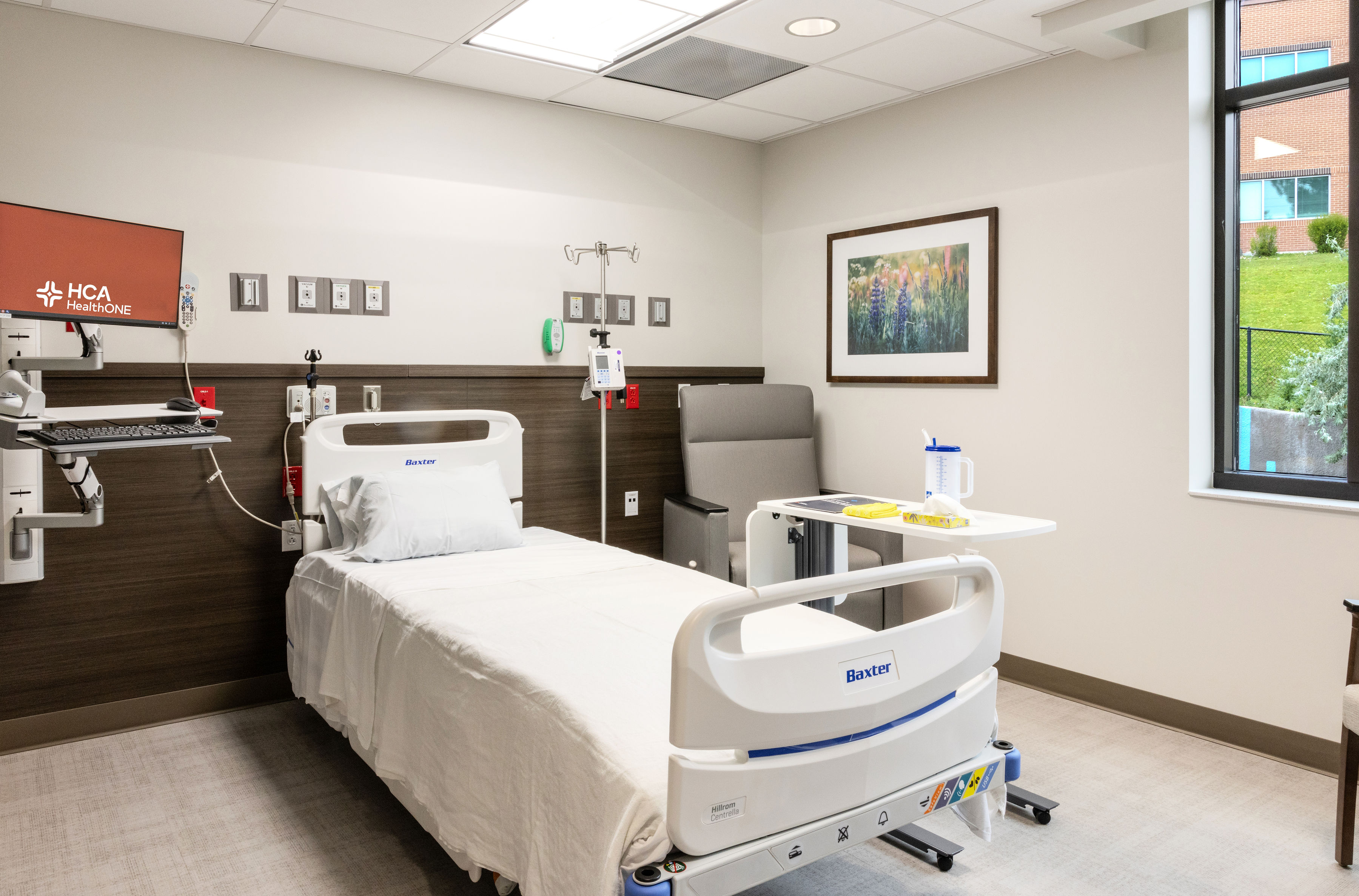 Hospital bed in hospital room next to window.
