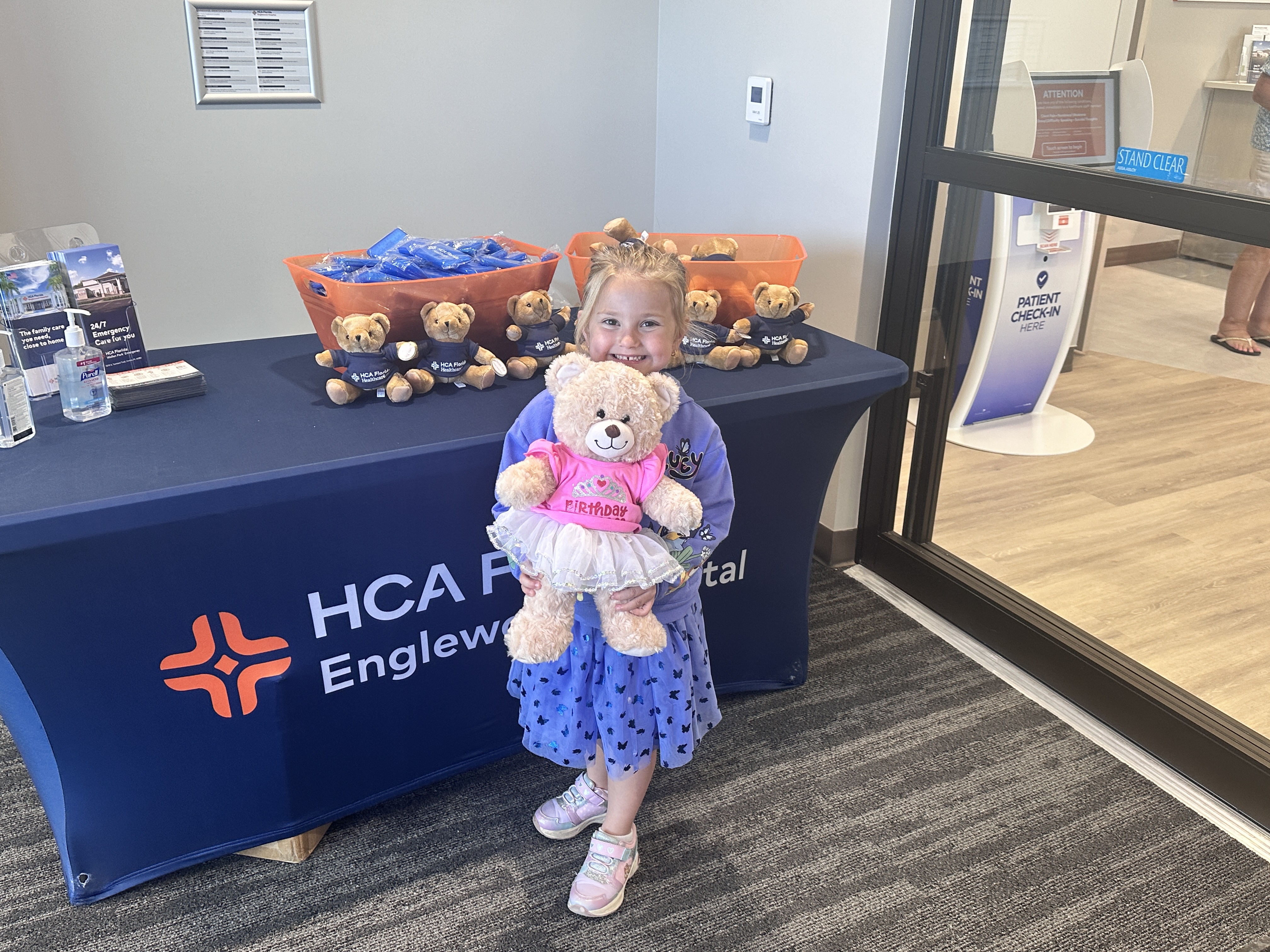 Molly Fisher holding Teddy Bear at Wellen Park Emergency ribbon cutting ceremony.