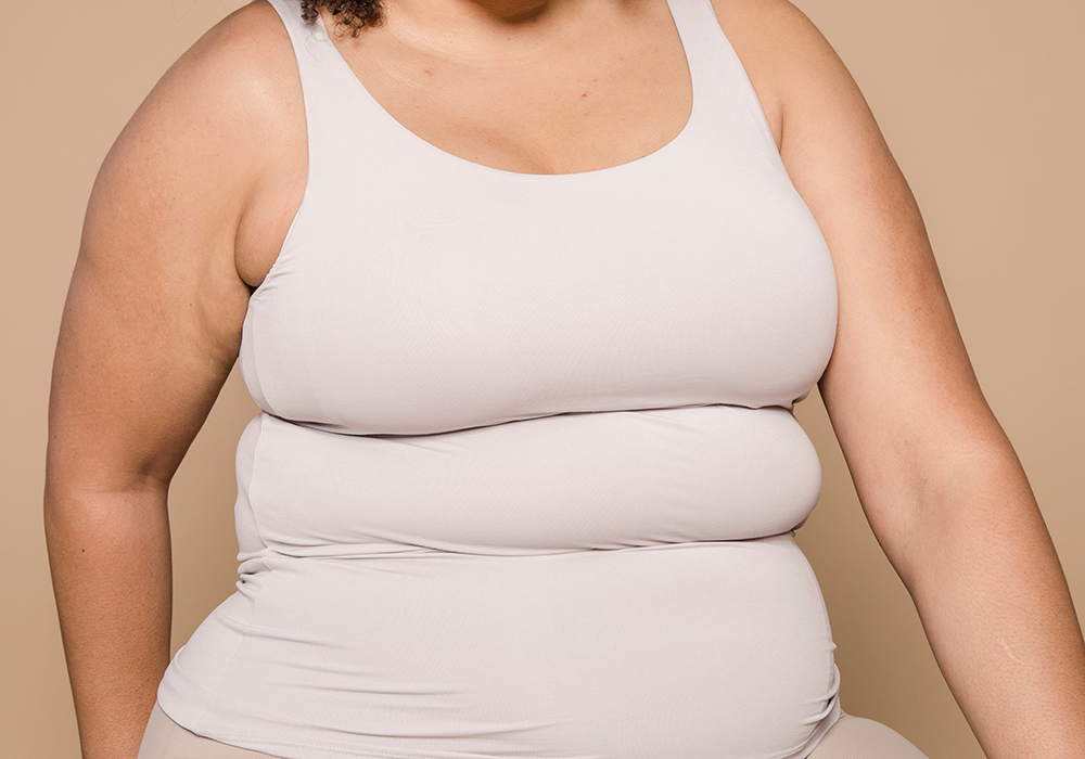 The torso of a woman wearing a white tank top.