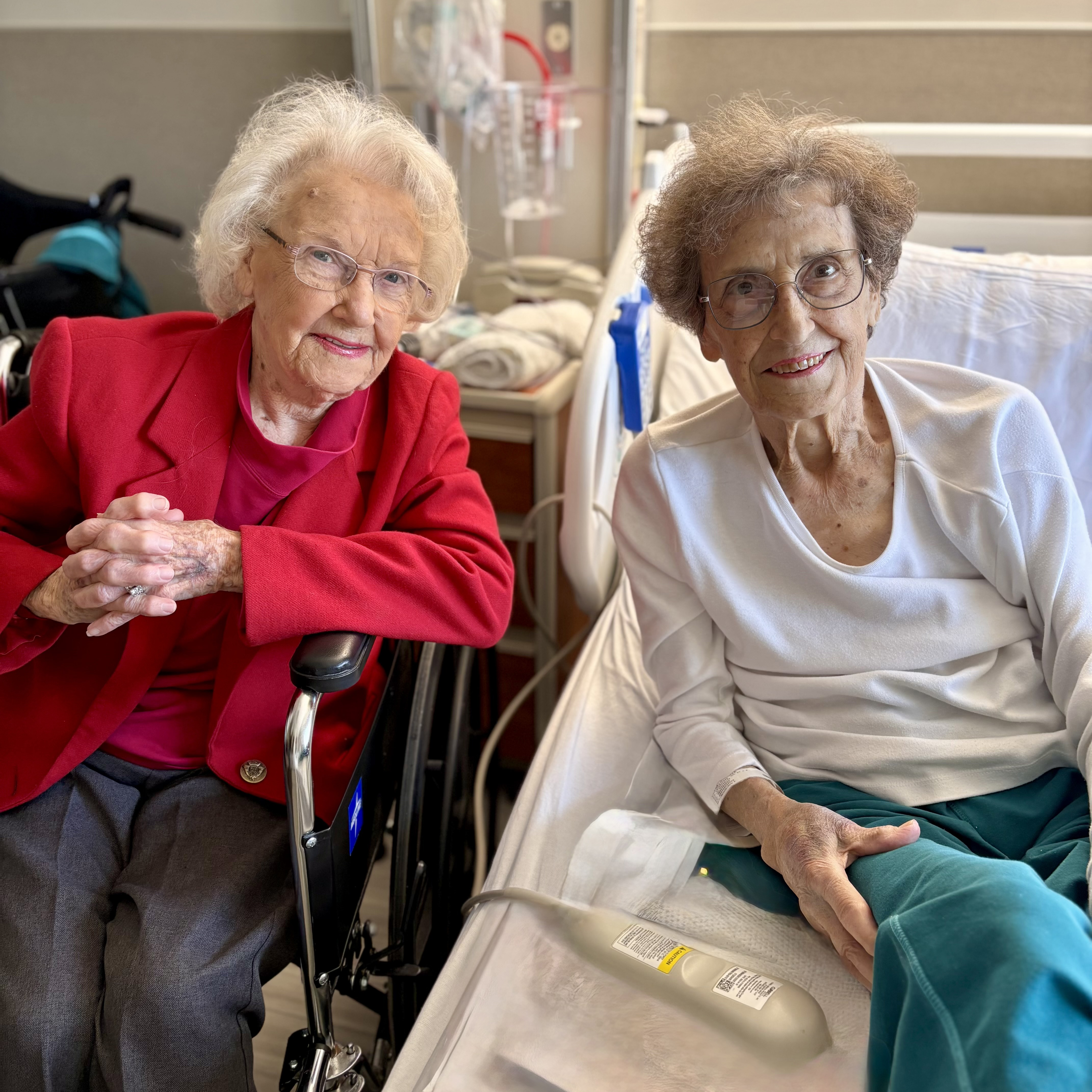 Sisters Jean and Jonnia sitting next to one another in their hospital room.