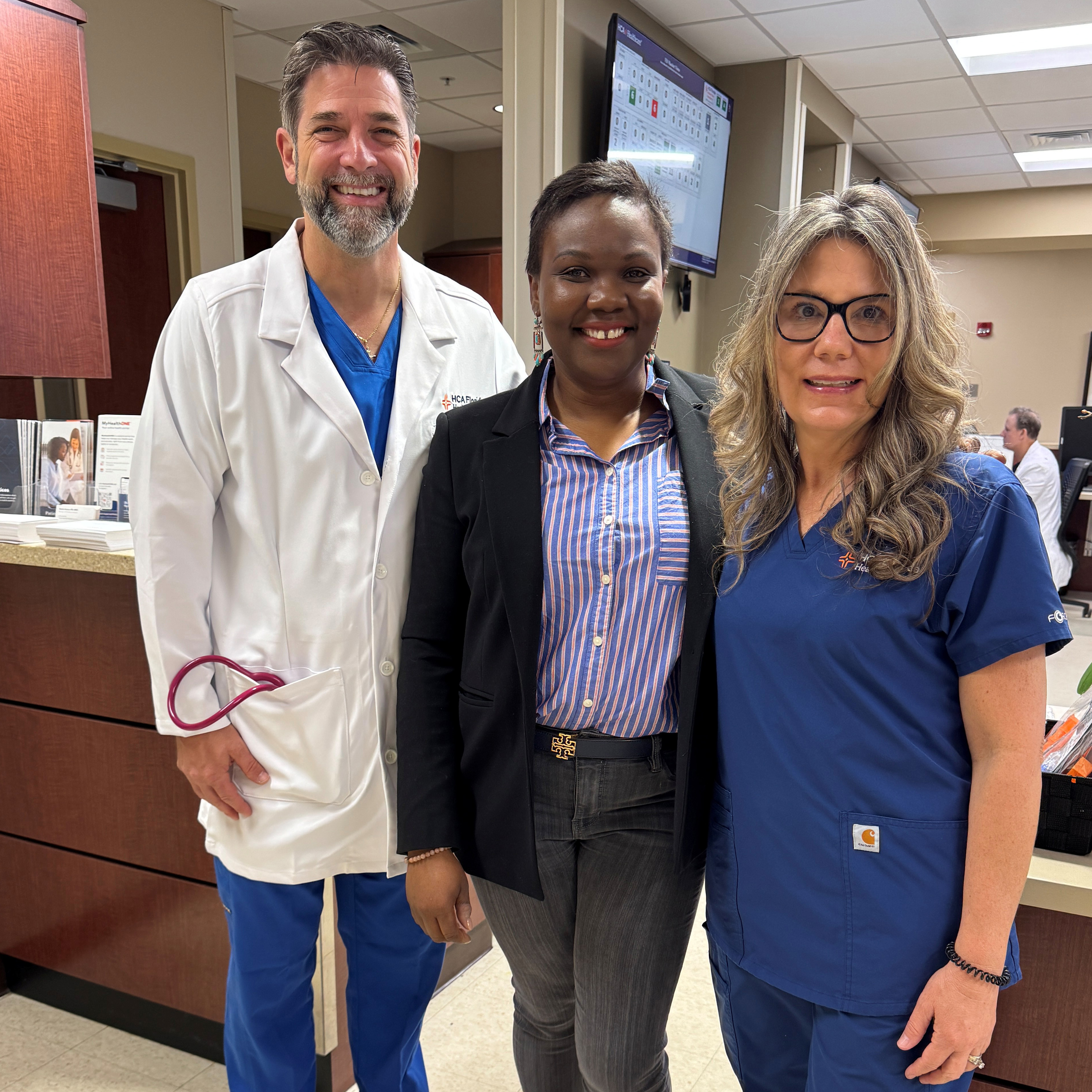 Astride Kovacik stands in the middle smiling with doctor and nurse by her side.