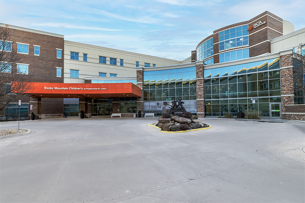 HCA HealthONE Rocky Mountain Children's Hospital main entrance, a four storied building with a mirrored glass front and red awning.