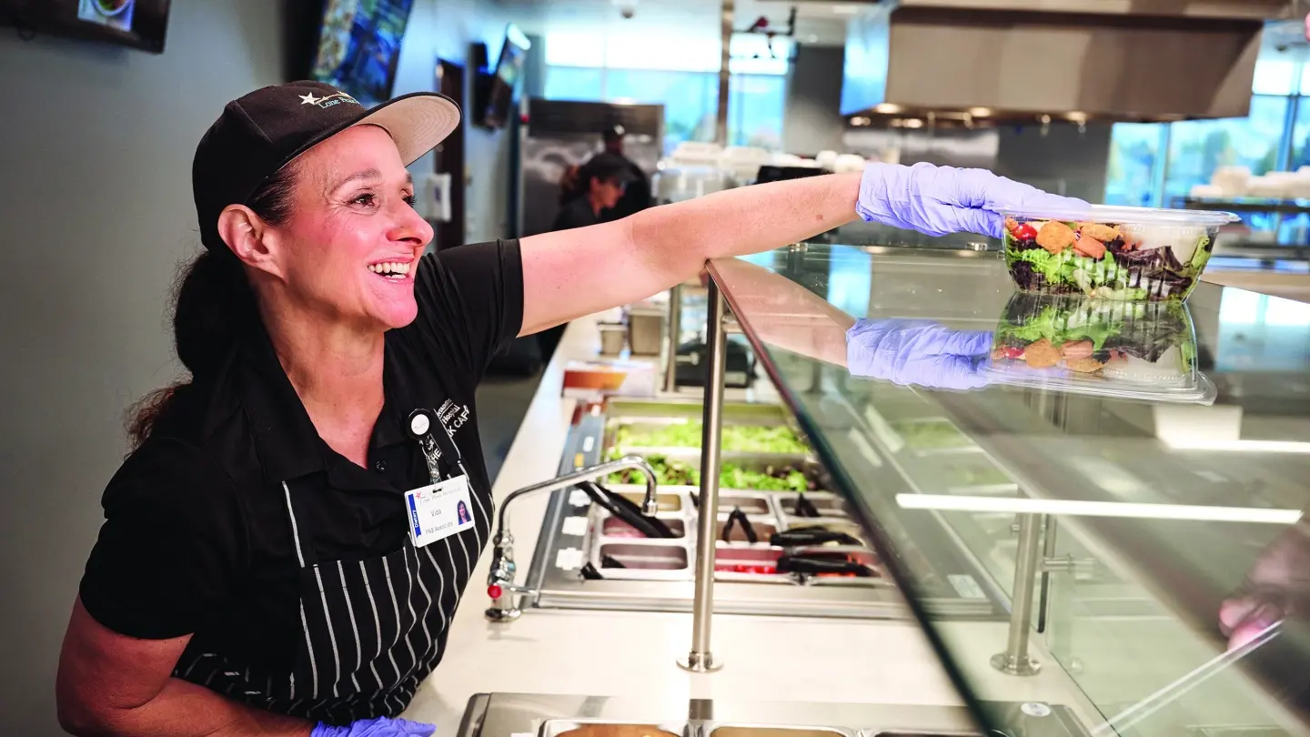 Cafeteria worker handing out food in the cafeteria