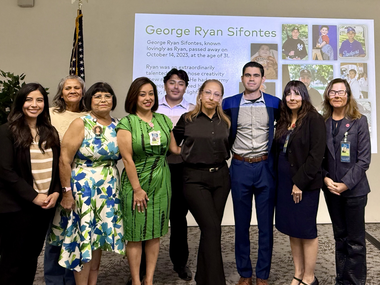OneLegacy and one of our family members pose for a photo infront of an image of her organ donor