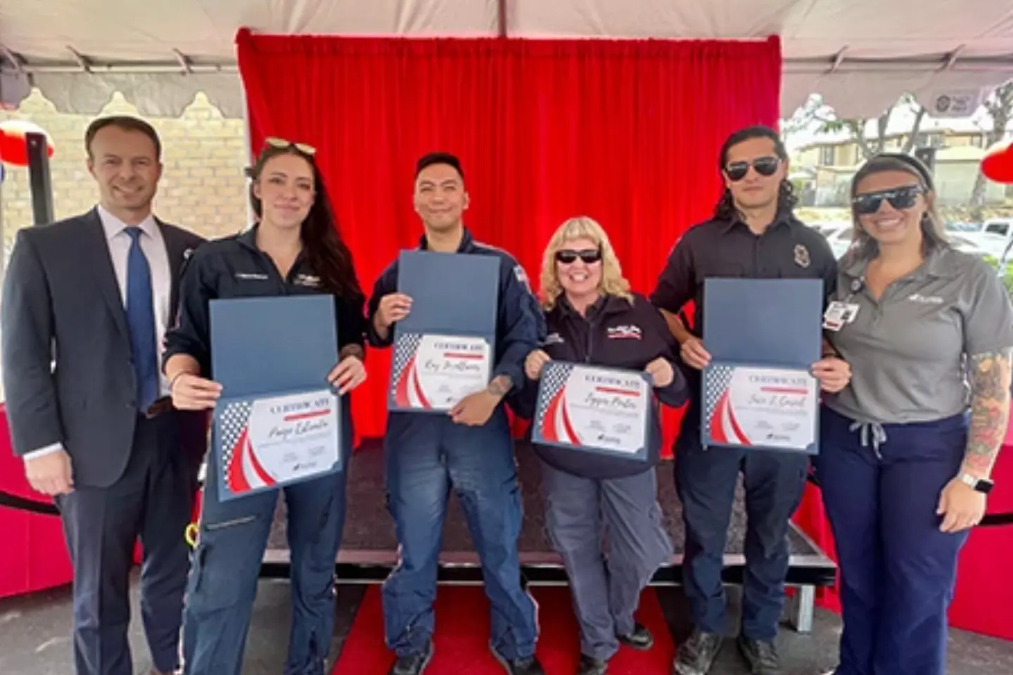 Paramedic Tigger P., EMT Jace C., Corona Fire Robert C. and Michael G., and Mercy 22 Ray J. and Paige E. smile while holding honorary certificates.