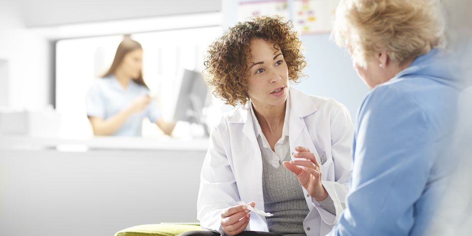 A doctor speaking to a patient about the importance of mammograms.