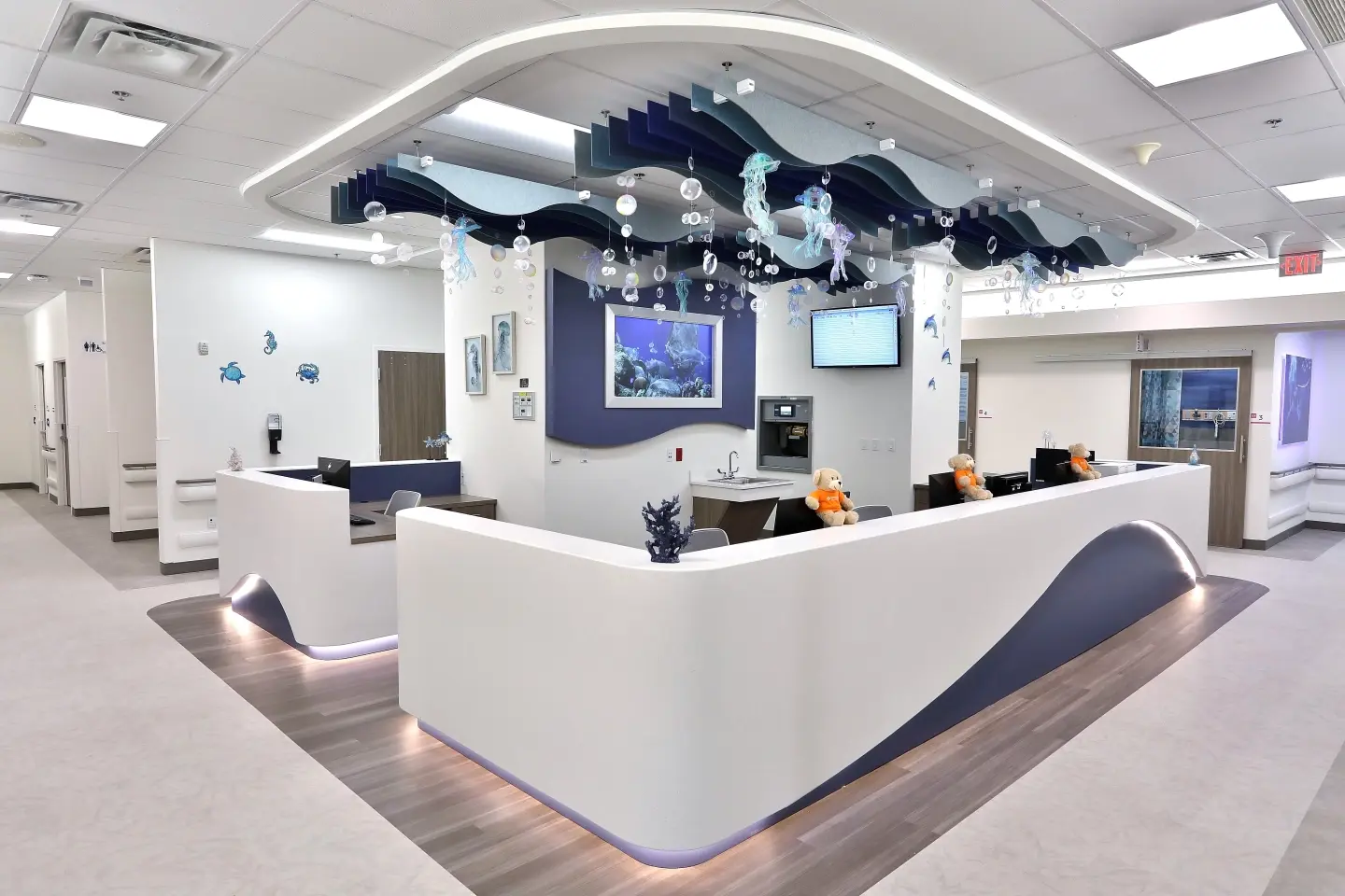 New pediatric nurse station, a multi-person wrap-around desk with modern design.