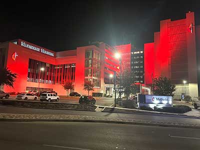 Hospital building bathed in red light to signify Heart Month