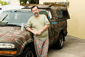 Glen Sapp leaning on his camoflauged truck