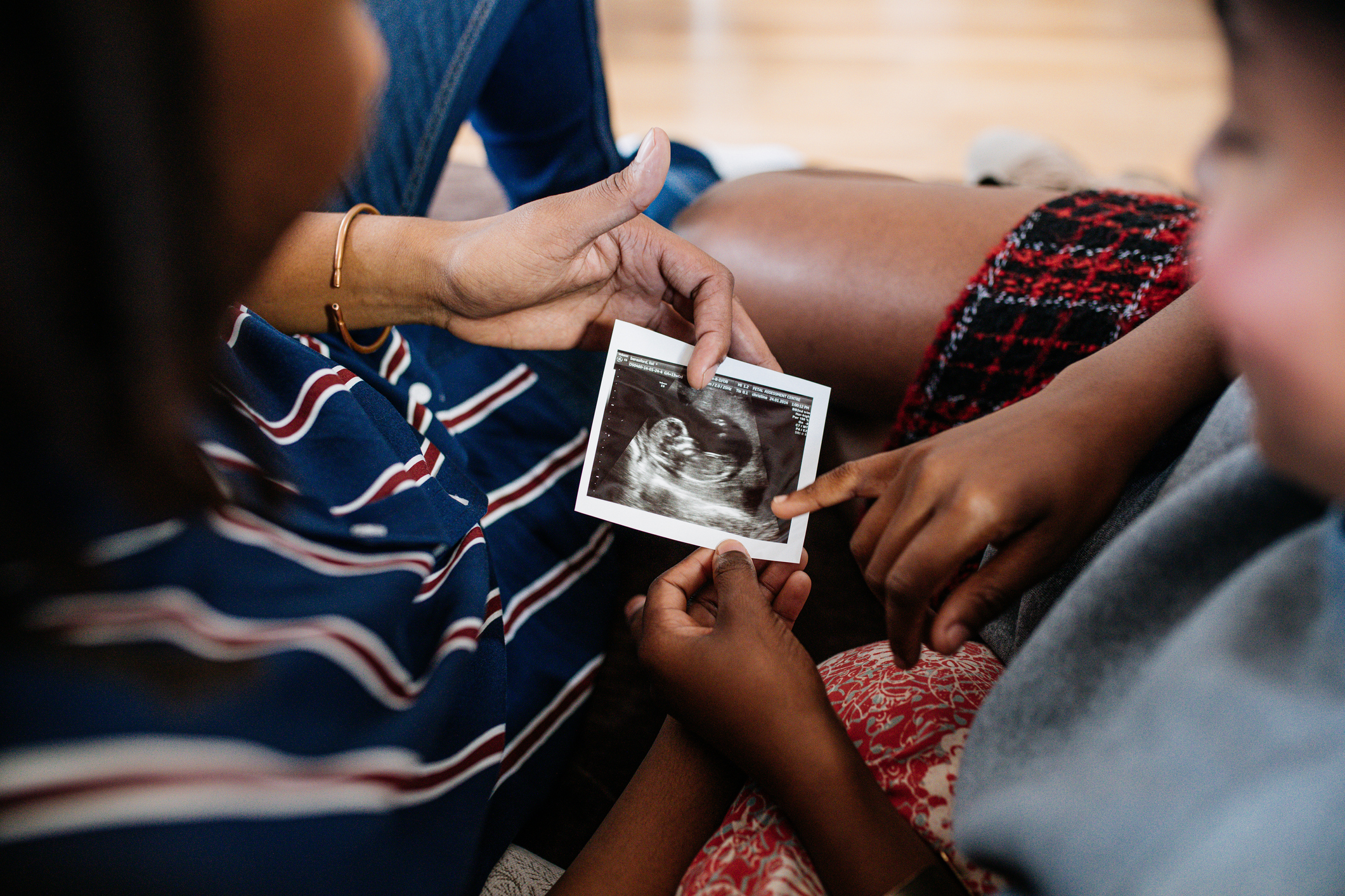 Young couple looking at pregnancy trimester ultrasound