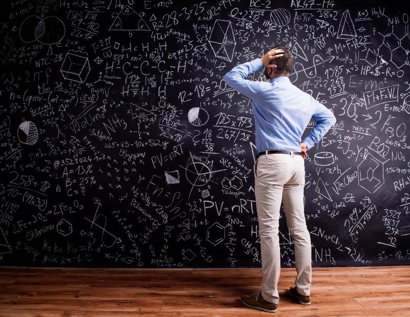 Dr. Huntsman at chalkboard fully covered in forumulas.