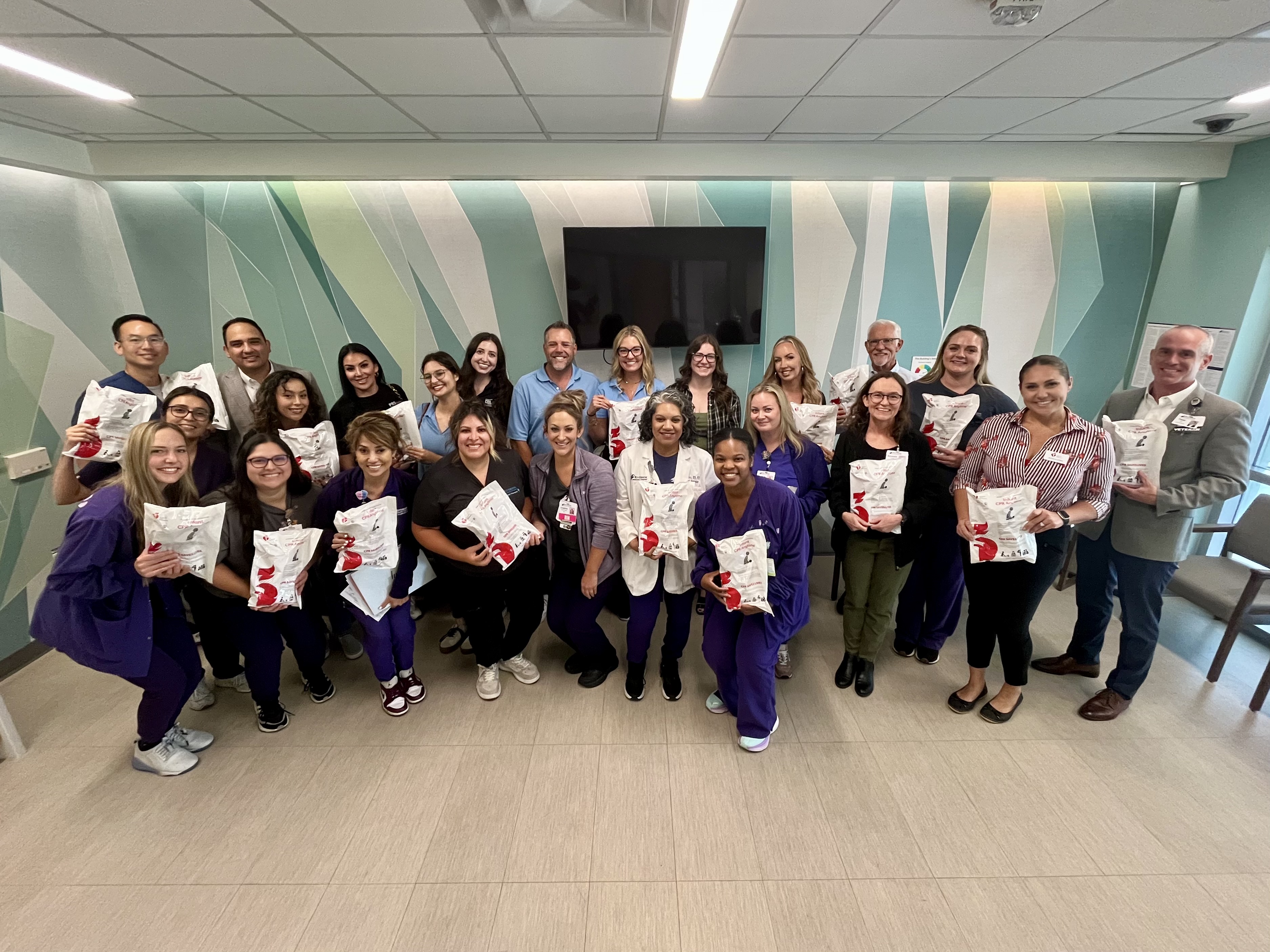 The RCH, PSR and AHA team posing for a group photo with the infant CPR kits