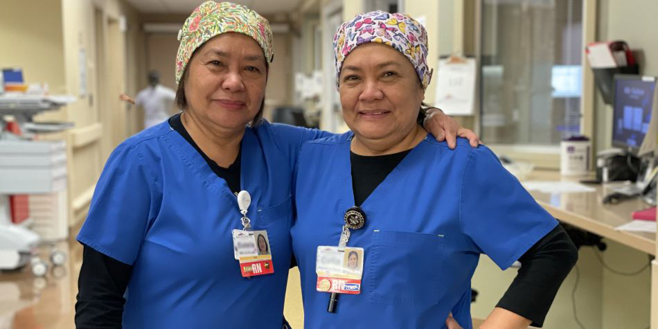 Neuro ICU nurses, and twin sisters, Estela I. and Celia A., standing together in their hospital ward, 