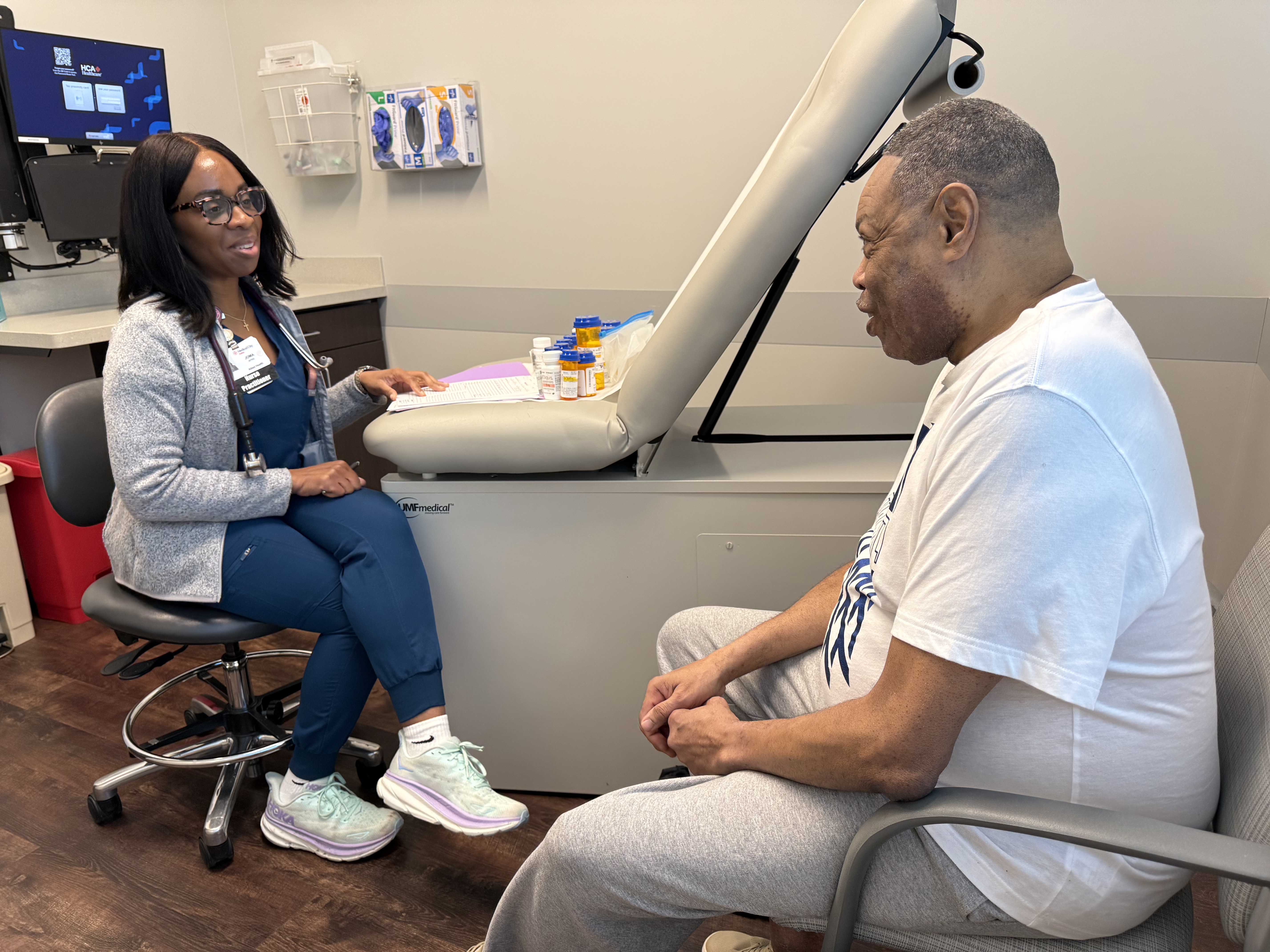 Nurse Practitioner Joma Okereke speaks with Marvin Roe.