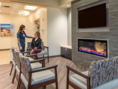 A virtual rendering of clinic staff consulting with a seated individual inside the waiting room of the Oncology suite at Portsmouth Regional Hospital.